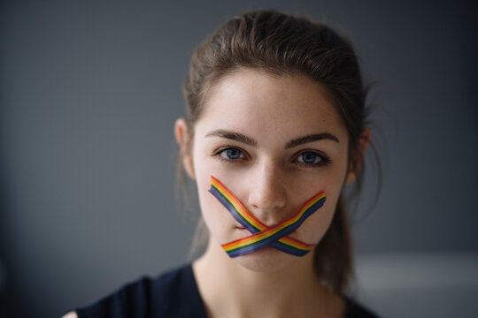 Portrait of young woman with LGBT sticky tape on her mouth
