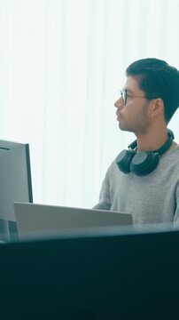 Vertical Screen : Young adult Asia male freelance eyeglasses typing write prompt AI bot app smart program nomad, video game, terminal with coding, user interface, big data center on desktop computer.