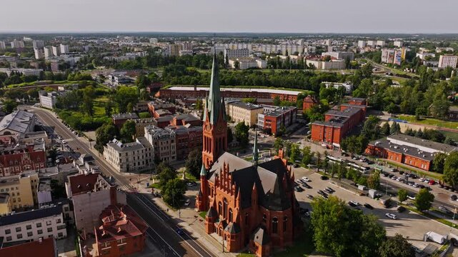 Drone captures Torun skyline with St. Catherine Church glowing in sunset