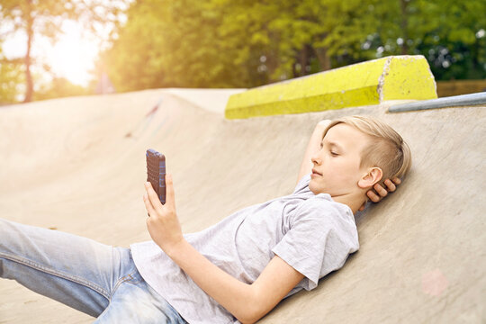 Boy using smartphone in skatepark