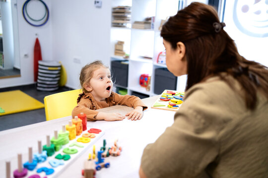 Speech therapist working with a child in a therapy room, focusing on communication and language development through engaging activities and professional support