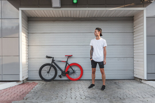Young man with fixie bike at a roller shutter