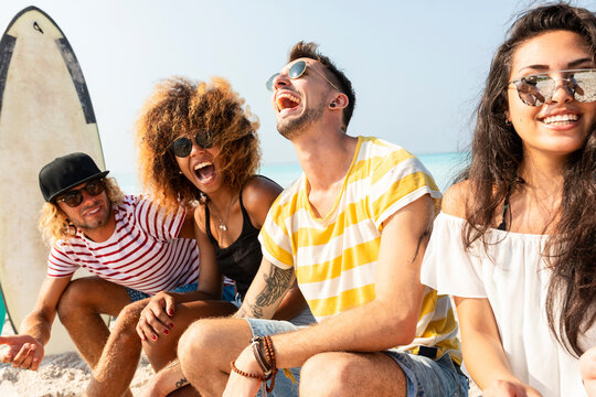 Friends sitting on the beach, having fun