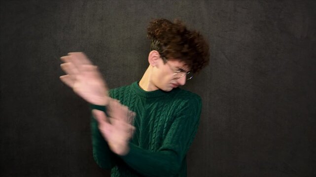 The man grimaces and points with his hands and finger.