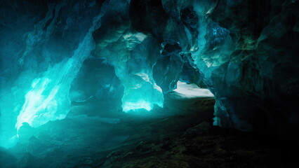 Obraz premium Visitors navigate through a mesmerizing ice cave, where vibrant blue lights illuminate the sparkling ice formations. Shadows dance along the rugged walls, creating an otherworldly atmosphere.