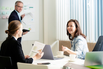 Fototapeta premium Expressive female leader explaining project to colleagues. Open hand gestures during business meeting. Teamwork and leadership concept.