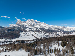 Sunny Winter Aerial Panorama of Cortina d'Ampezzo with Snowy Tofane Mountains, Dolomites, Italy