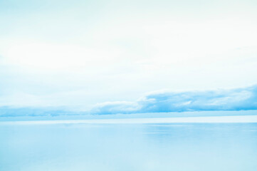 Fototapeta premium Serene blue seascape reflection under a light cloudy sky