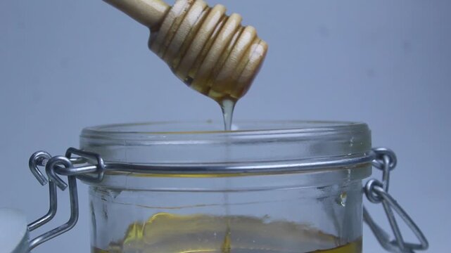 honey dripping from a jar on white background