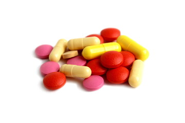 There is a pile of different pills on a white background.