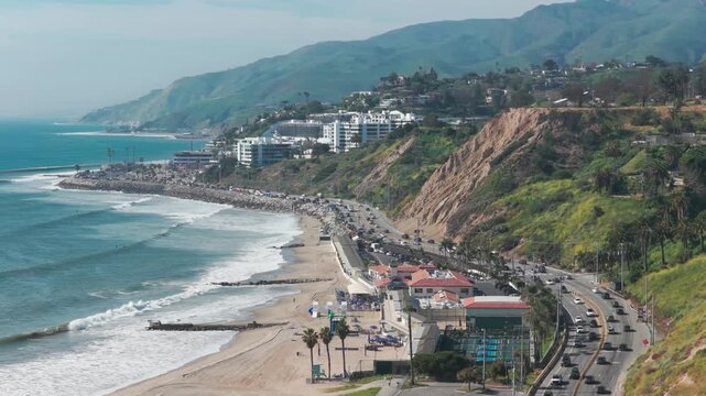 Aerial telephoto dolly shot of Will Rogers State Beach during springtime in Pacific Palisades, California. 4K