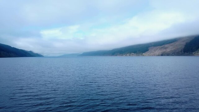 Tracking In Low Drone Shot with slight left Pan of Loch Ness early in the morning.