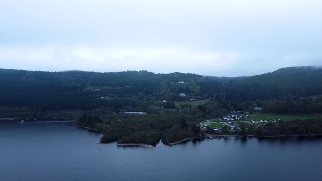 A wide aerial shot of a campervan site on the shores of Loch Ness, tracking rightwards in the early morning of a scottish summer day.