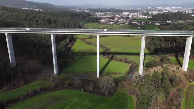Drone shot of highway viaduct over lush green fields