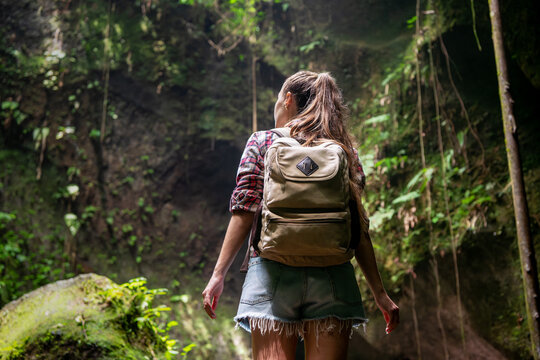 Tourist girl looking at a leafy wall in the jungle on Bali