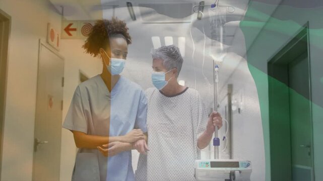 Nurse guiding on cue down ward corridor for ambulation, patient with IV pole while overlay shifting