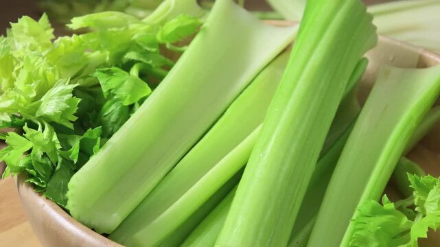 Fresh celery in a wooden bowl.	