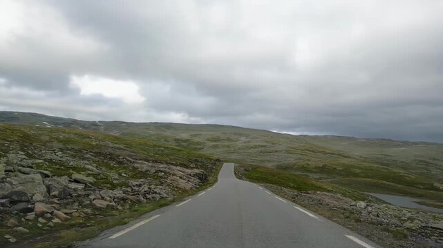 POV from a car driver driving along the narrow Bj&oslash;rgavegen road in Aurland, Norway, following a winding mountain route through Nordic landscape with no people