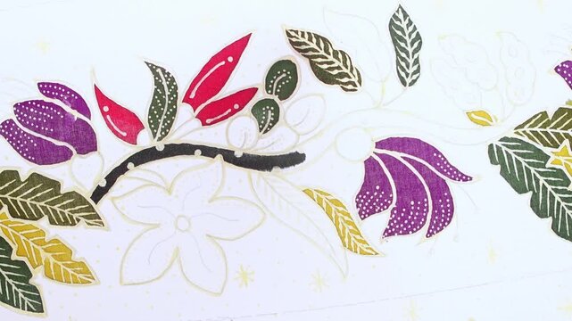 Indonesian artisan painting a traditional floral batik pattern