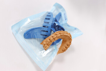 Dental jaw impression and blue trays inside sterile package.
