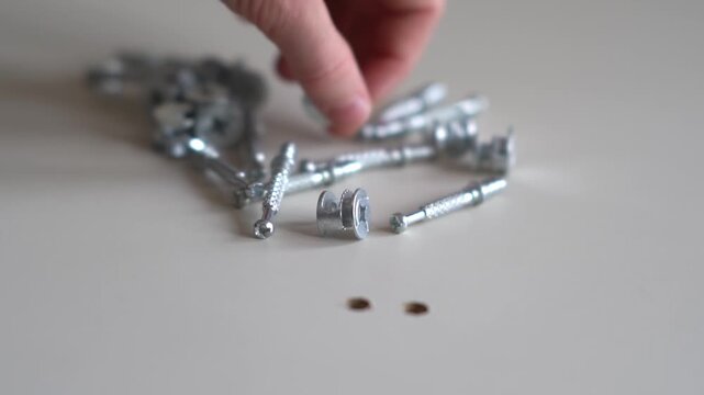 Furniture assembly. Furniture assembly fittings. Furniture building parts, screws and bits and pieces at home for to assemble, searching for the right item