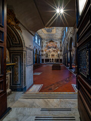 Obraz premium Santa Maria Assunta: Dramatic Duomo side tunnel: tiled walls glowing, red floor leading to sacred icons/pews.
