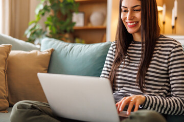 Woman working remotely from home using laptop computer