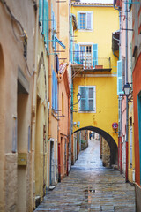 Fototapeta premium Vibrant view of colorful buildings with blue shutters and national flags in a coastal Mediterranean town