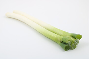 白背景に映える鮮やかな緑色の長ネギの葉