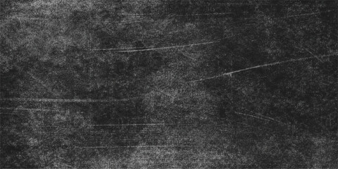 An abstract black and white grunge background features a dark textured chalk board surface with aged grey stone and rough scratched concrete patterns for a vintage wall design © hossain