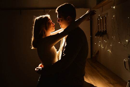 Silhouette of loving couple embracing and hugging each other in the kitchen. Happy young couple in love. Love, romantic, tenderness and Valentines day