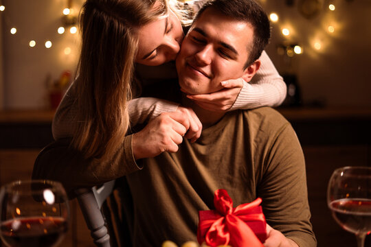 young couple in love kissing having romantic dinner and celebrating Valentines day at home