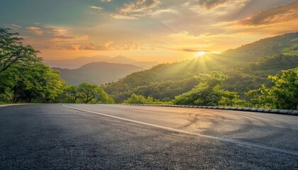 Scenic landscape view of a winding road through lush green mountains at sunset against a colorful sky