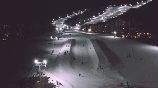 Downhill Skiing and Snowboarding at Night in Steamboat Springs, Colorado, USA - Aerial Drone View in HD and 4K