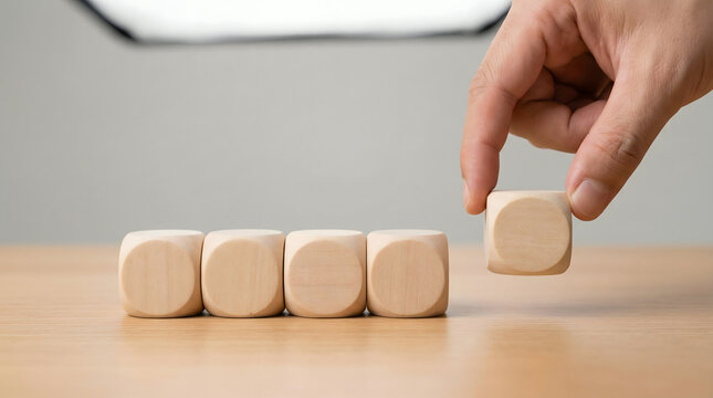 Hand placing last wooden cube in a row, decision making concept