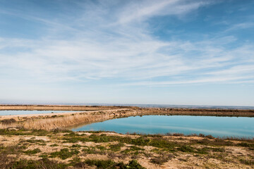 Minimal panoramic view of calm freshwater reservoir reflecting soft blue sky. Peaceful rural environment with clean horizon and open copy space.