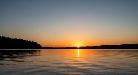 Obraz premium Tranquil lake sunset landscape with orange sky and water reflections