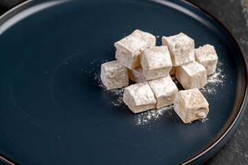 soft and fresh Turkish delight with powdered white sugar, cubic sweet white soft pieces of Turkish delight with nuts and dried fruits inside
