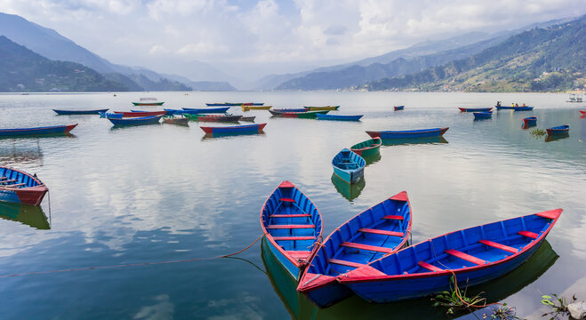 Phewa lake with traditional wooden boats in Pokhara, Nepal