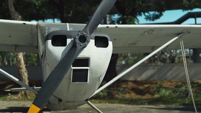 An old aluminum propeller aircraft stands on the site with engines muffled. Retro aviation.