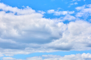 Fototapeta premium Fluffy white clouds against a clear blue sky