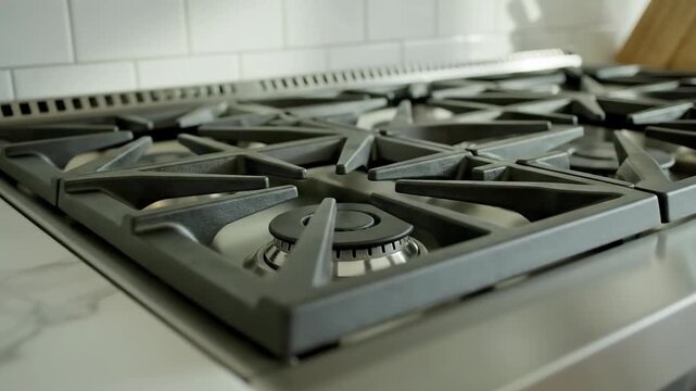 Luxury stainless steel gas range with multiple burners and marble countertop in modern kitchen