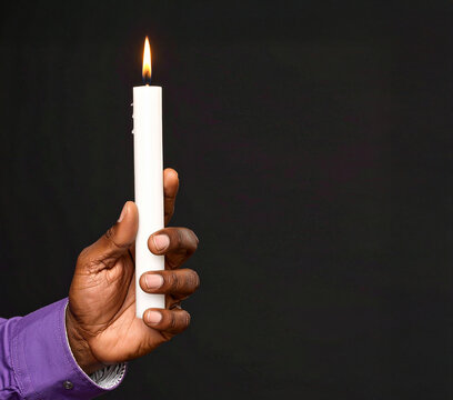 Mano con una vela encendida sobre fondo negro, s&iacute;mbolo de fe cristiana, Cuaresma y Semana Santa, vigilia religiosa, penitencia, esperanza, oraci&oacute;n, recogimiento, devoci&oacute;n, sacrificio y fe cristiana