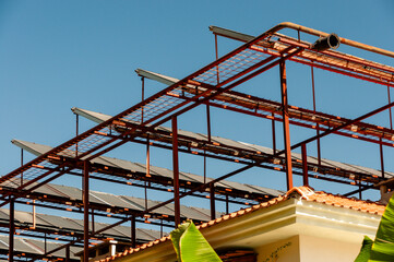 Solar panels on a metal frame on the roof of a building in a hot climate