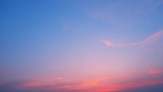 A beautiful sunset sky timelapse video capturing soft cirrus and thin altostratus clouds drifting across a pink and orange horizon, revealing gentle color gradients in the calm evening atmosphere.

