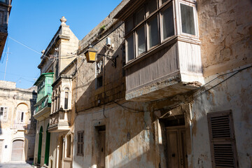 Obraz premium Wooden balconies on traditional houses in the arrow alleyways of Victoria Old Town, Gozo, Malta.