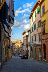 Naklejka premium Medieval narrow street in Siena, Tuscany, Italy. Architecture and landmark of Siena. Cozy cityscape of Siena
