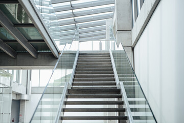 Minimalist concrete stairs with glass railing in modern interior.