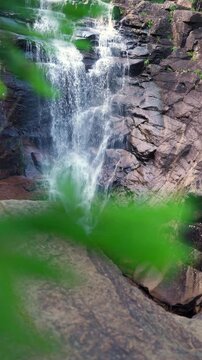 Scenic view of natural waterfall in lush green Norwegian forest. Flowing water, rocky stream, and peaceful surroundings promote eco tourism, relaxation, and nature-inspired travel lifestyle.