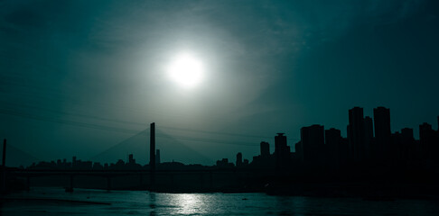 The silhouettes of city skyline surrounded by the sea under the sunlight during the sunset in Chongqing, China